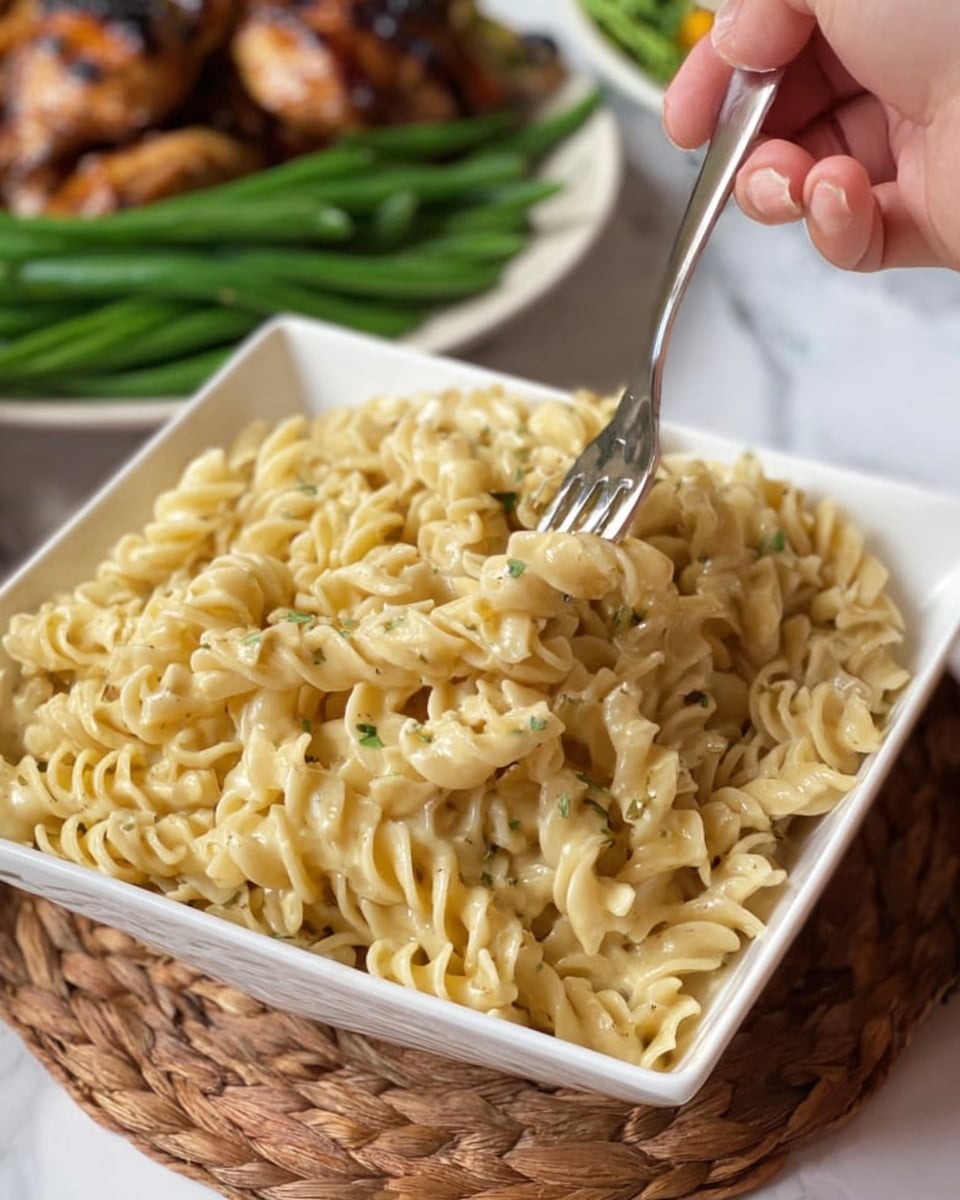 A white rectangular plate holds three layers of food: on the left side, there is a large pile of soft yellow egg noodles with a shiny, slightly oily texture; in the middle, a neat row of fresh green beans with a smooth and crisp appearance; on the right side, two golden-brown roasted chicken thighs with a crispy texture and slightly browned skin. A woman's hand is holding a fork above the noodles, ready to take a bite. In the background, there is a white bowl full of more yellow egg noodles. All of this is set on a white marbled surface. photo taken with an iphone --ar 4:5 --v 7