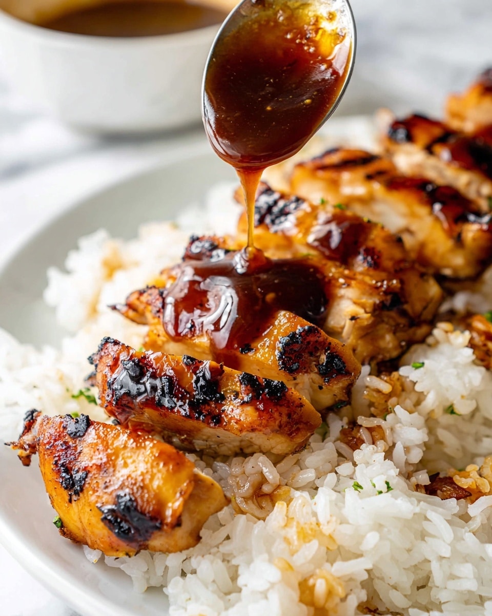 The image shows slices of grilled meat with a shiny, sticky brown sauce being poured over them with a spoon. The meat pieces are arranged in one layer and have grilled marks and a glossy texture. Underneath the meat is a layer of cooked white rice, with some grains slightly stained by the sauce. The whole dish is placed on a white plate, set against a white marbled surface. Photo taken with an iphone --ar 4:5 --v 7