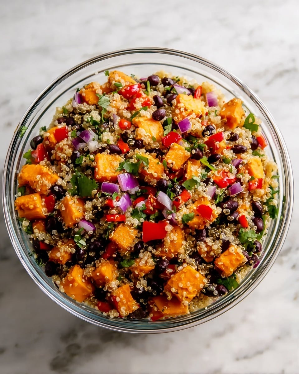 A clear glass bowl filled with a colorful quinoa salad, showing a mix of four main layers: the bottom layer contains light beige quinoa seeds with small round shapes, scattered evenly; above it, bright orange roasted sweet potato cubes add texture and vibrancy; mixed throughout are black beans providing a shiny black contrast; and on top, chopped red bell peppers, small purple onion pieces, and green cilantro leaves add pops of red, purple, and green colors that create a fresh, mixed look. The bowl is placed on a white marbled textured surface. photo taken with an iphone --ar 4:5 --v 7