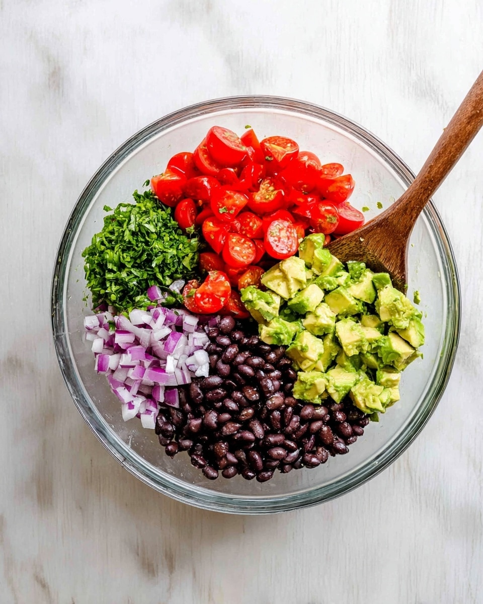 A clear glass bowl sits on a white marbled surface, divided into five colorful sections: bright red halved grape tomatoes at the top right, finely chopped green herbs below them, solid black beans to the bottom right, small chopped purple onions to the bottom left, and chunky diced avocado with a light green color on the top left. A wooden spoon with a smooth texture is placed in the bowl, resting mainly on the black beans and herbs. The ingredients are fresh, vibrant, and cleanly separated in this fresh salad mix. photo taken with an iphone --ar 4:5 --v 7