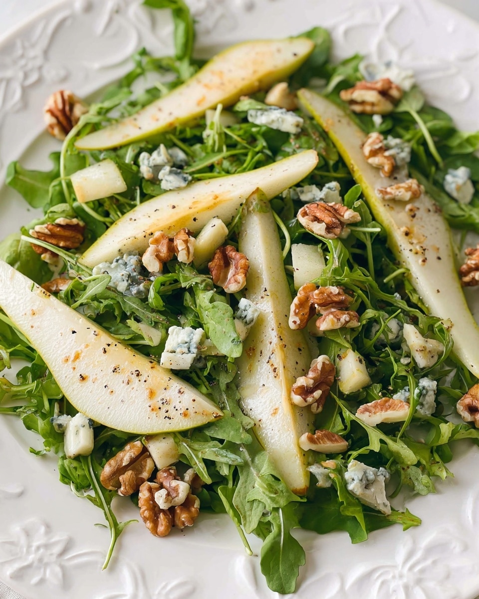 The image shows a fresh salad with three main layers: at the bottom is a bed of bright green arugula leaves with a crisp texture, on top are thin slices of light green pear with a smooth, juicy look, and scattered around are uneven chunks of creamy white blue cheese with blue veins. Small pieces of brown walnuts are evenly spread throughout the salad, adding a rough texture. A light yellow dressing is being poured over the salad from a black-tipped container onto a pear slice, creating a glossy shine. The salad is served on a white plate with an embossed floral pattern, set on a white marbled surface. Photo taken with an iphone --ar 4:5 --v 7