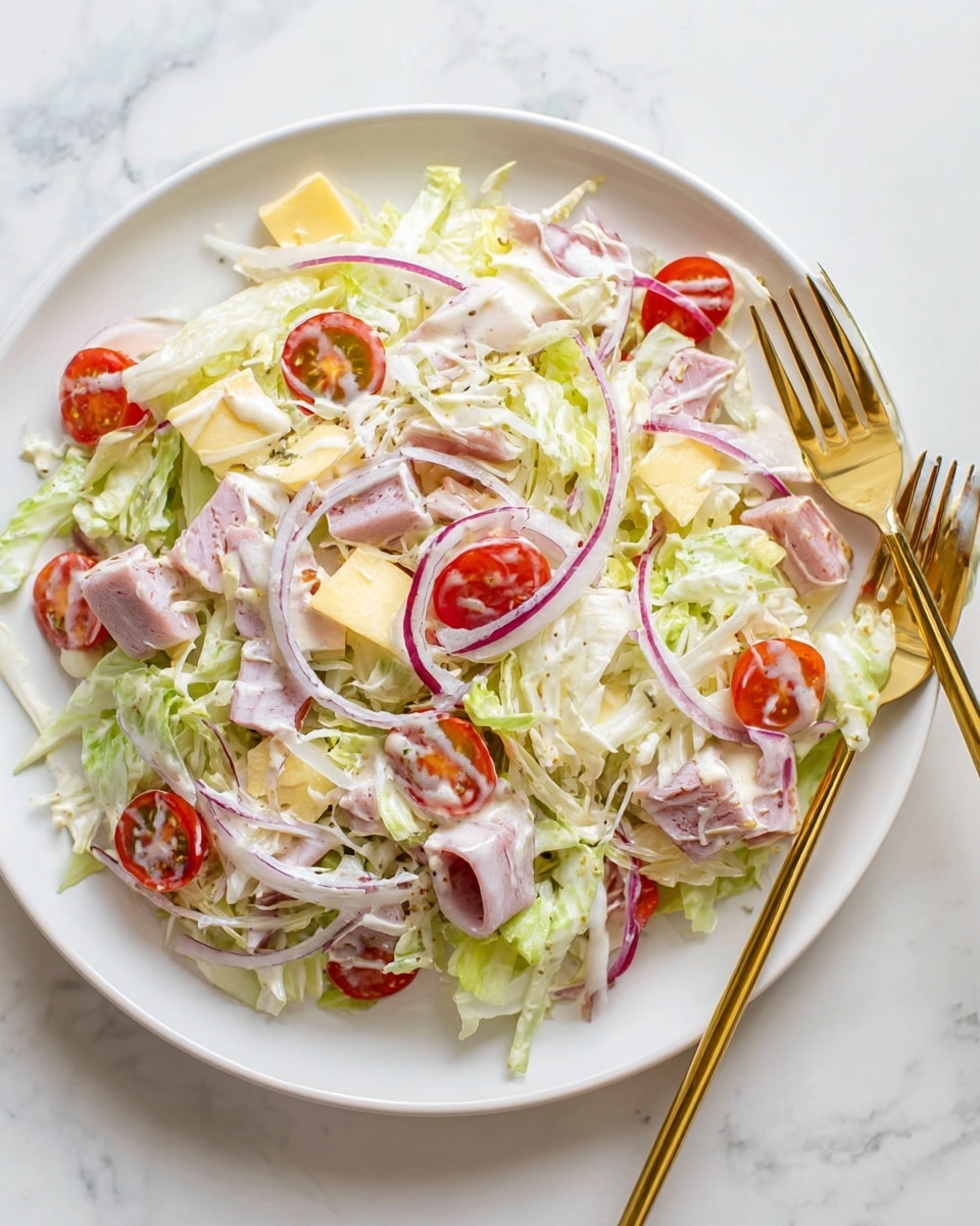 A fresh salad in a white bowl placed on a white marbled surface, showing multiple thin layers of shredded green lettuce as the base, mixed with halved bright red cherry tomatoes and thin slices of purple onion. Scattered over the greens are square pieces of pale yellow cheese, small chunks of light pink ham, and creamy white dressing drizzled unevenly on top, with some yellow pepper slices adding a slight pop of color. The textures vary from crisp vegetables to smooth cheese and creamy dressing, creating a colorful, fresh look. photo taken with an iphone --ar 4:5 --v 7