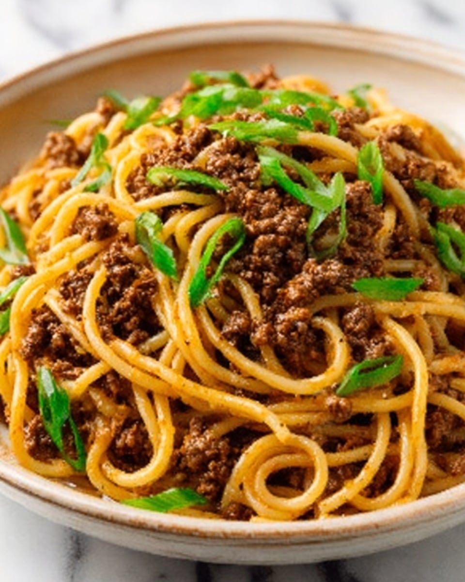 A wooden bowl filled with a serving of stir-fried yellow noodles mixed with small pieces of brown cooked meat. Bright green leafy vegetables are placed on one side, giving a fresh contrast to the noodles. A pair of chopsticks held by a woman's hand is lifting some noodles above the bowl, showing the texture of the long, slightly shiny noodles. The bowl is on a white marbled surface. photo taken with an iphone --ar 4:5 --v 7