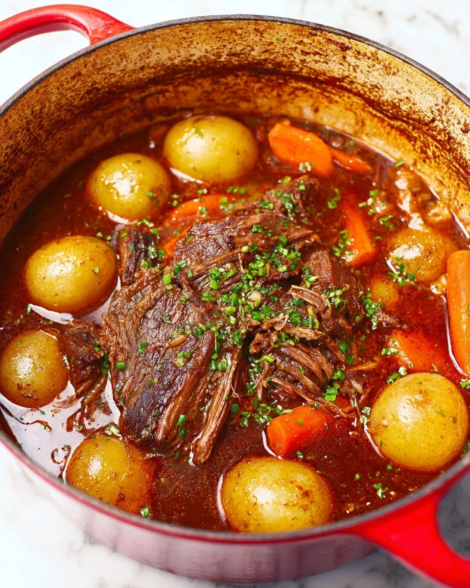 A close-up view of a red cast iron pot filled with a juicy, browned beef roast in the center, surrounded by rich dark brown sauce that glistens with a shiny texture. Around the beef are several bright orange carrots and small golden potatoes, all partially submerged in the sauce. The dish is sprinkled with fresh green herbs on top of the beef, adding a pop of color. The inside rim of the pot shows caramelized browned marks from cooking. The pot rests on a white marbled surface. photo taken with an iphone --ar 4:5 --v 7